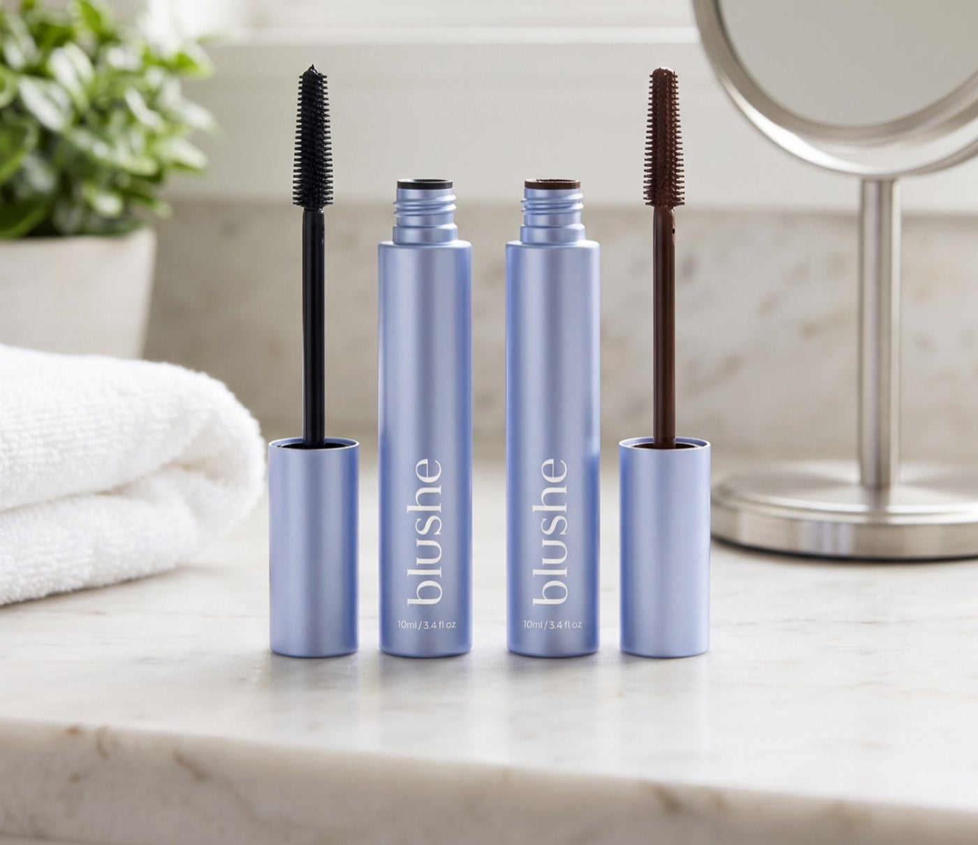 Two Blushe tubes on a marble counter, one with a black wand and one with a brown wand